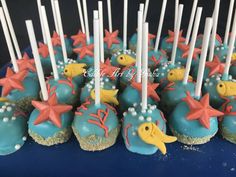 there are many cupcakes decorated with sea animals and stars on the blue plate