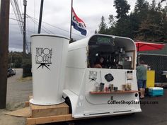 a food truck is parked on the side of the road with people standing around it