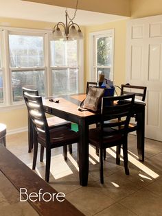 a dining room table with four chairs and a bench in front of the window that is open