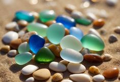 many different colored glass pebbles on the sand