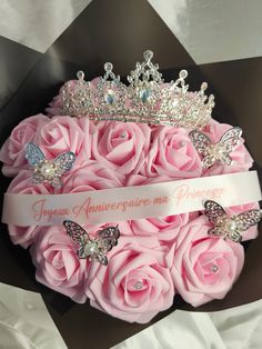 a bouquet of pink roses with a tiara on top