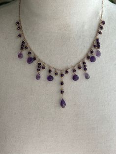 "17 1/2\" (plus 1\" extender) necklace featuring amethyst briolettes/drops, amethyst rondelles and spacer beads on chain.  I hand wire wrapped the amethyst stones with briolettes on the bottoms in various lengths onto 14k gold filled chain. Each rondelle is encased between 2 gold filled spacer beads. The longest drop length is in the center. It is 1 3/4\" long and is made up of 3.5mm amethyst rondelles with a faceted 7x11mm drop on the bottom. On each side of the center is a single amethyst rond Amethyst Beaded Necklace, Purple Teardrop Necklace For Jewelry Making, Amethyst Briolette Necklace For Jewelry Making, Purple Teardrop Necklaces For Jewelry Making, Adjustable Purple Necklaces With Dangling Beads, Purple Wire Wrapped Necklaces With Round Beads, Lavender Dangling Beads For Jewelry Making, Purple Teardrop Jewelry With Dangling Beads, Adjustable Purple Necklace With Dangling Beads