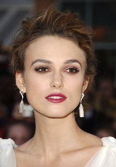 a woman in white dress with earrings on her head