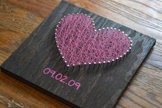 a pink heart shaped hair comb sitting on top of a wooden board with the word po sopo written in it