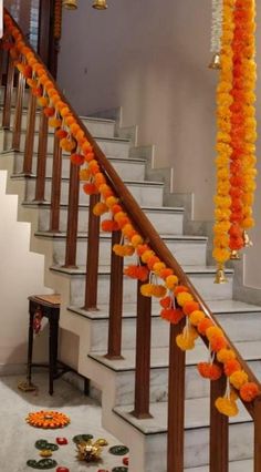 the stairs are decorated with orange garlands and decorations for diwaling on them