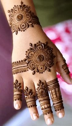 a woman's hand with henna tattoos on it