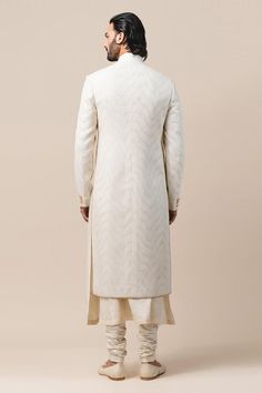 Ivory sherwani with all-over abstract pattern applique-thread work. Comes with kurta and churidar. 
Component: 3
Embroidered
Neckline: Mandarin Collar
Sleeve Length: Full
Fabric: Katan Silk, Poplin Lycra
Color: White
Side slits
Closure: Sherwani: Button front placket
Note: Pocket square worn by the model is not for sale
 - Aza Fashions Designer Off-white Bandhgala For Eid, Designer Off White Kurta For Eid, Designer Off-white Kurta For Eid, Designer Off White Traditional Wear With Chikankari Embroidery, Designer Off-white Traditional Wear With Chikankari Embroidery, Designer White Nehru Jacket, Designer Cream Kurta With Cutdana, Designer Off White Kurta With Resham Embroidery, Designer Unstitched White Kurta