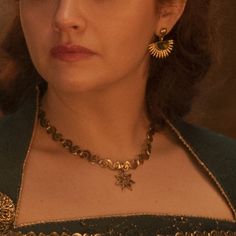 a close up of a person wearing a necklace and earring on her head,