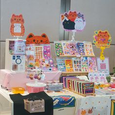 there are many different items on display at this market stall, including cards and magnets