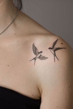 a woman with a tattoo on her shoulder has two birds in flight above her chest