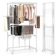 a white rack with clothes and pants hanging on it's sides next to another rack