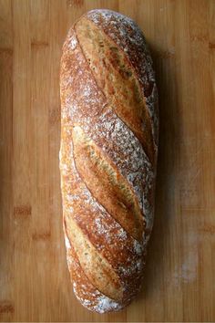 a loaf of bread sitting on top of a wooden cutting board