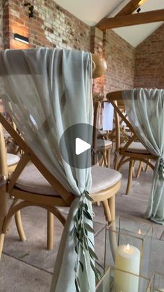 chairs with drapes and candles on them in an indoor setting for a wedding ceremony