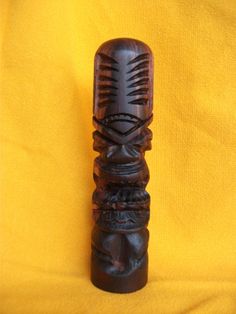 a carved wooden object sitting on top of a yellow cloth