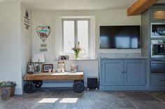 Reclaimed oak wood cart sits in front of window with traditional painted bespoke kitchen cabinets Bespoke Kitchen Cabinets, Wood Cart, Reclaimed Oak, Uk Kitchen