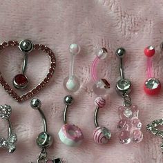 there are many different types of belly rings on the bed together, including one with a heart