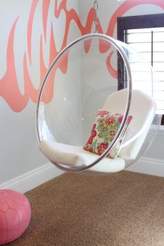 a swing chair hanging from the ceiling in a child's room with pink accents