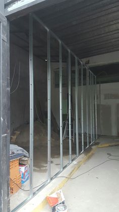 the inside of a building that is being constructed with glass walls and steel framing on each side