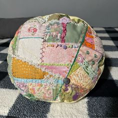 a patchwork purse sitting on top of a black and white checkered floor