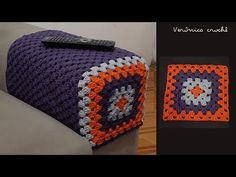 a crocheted blanket sitting on top of a couch next to a remote control