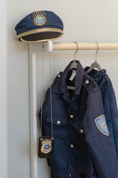 a police uniform and hat hanging on a coat rack