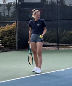 a woman standing on a tennis court holding a racquet and ball in her hand