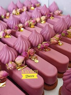 there are many pink cupcakes with gold decorations on them