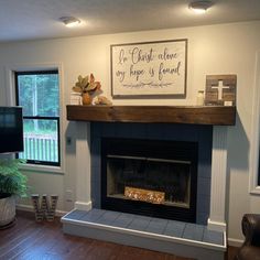 a living room with a fire place and a cross on the fireplace mantel above it