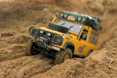 a yellow toy truck is in the sand