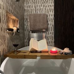 a candle is lit in front of an open book on a bathtub