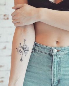 a woman's arm with a tattoo on it and an arrow in the middle