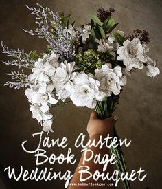 a vase filled with white flowers on top of a table next to a sign that says jane austen book page wedding bouquet