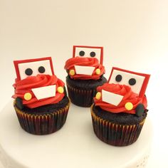 three decorated cupcakes with cars on them