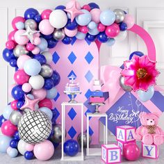 a pink and blue birthday party with balloons, teddy bears, cake and other decorations