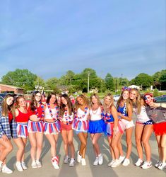 a group of young women standing next to each other in front of a parking lot