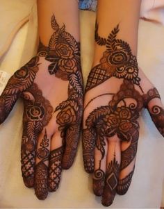 two hands with henna tattoos on them