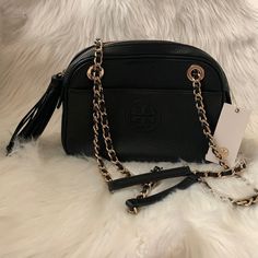 Tory Burch Bombe Pebble Leather Convertible Chain Bag *New With Tags *Black Pebble Leather Exterior *Black Tory Burch Logo Printed Canvas Interior *Interior: (1) Zip Slot *Exterior: (2) Magnetic Closure Slip Slots *Top Zip Closure, Gold-Tone Hardware *Black Pebble Leather Tassel Zipper Pull *Convertible Gold-Tone Chainlink/Pebble Leather Crossbody Shoulder Strap Or Double Handles *Approximate Dimensions: 9" X 6" X 3" Classic Black Bag With Gold Chain, Black Pebbles, Printed Canvas, Tory Burch Bag, Chain Bag, Leather Tassel, Chain Bags, Magnetic Closure, Pebbled Leather