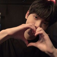 a young man making a heart with his hands