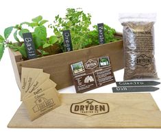 an assortment of herbs and seeds in a wooden box with labels on the side, along with seed packets