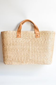 This airy, straw tote bag is finished with natural leather handles and a classic linen lining. Versatile and stylish, it's the perfect partner for airy dresses, summer prints or white denim. Content:- Straw- Leather - Linen Lining- Imported Size:- Width: 18.25" - Height: 12"- Depth: 6.59"- Handle Drop: 4.5" Chic Natural Beach Bag With Handles, Spring Jute Straw Bag With Leather Handles, Chic Beach Bag With Rolled Handles For Travel, Chic Beige Beach Bag With Leather Handles, Spring Travel Straw Bag With Rolled Handles, Spring Vacation Beach Bag With Rolled Handles, Spring Jute Beach Bag With Leather Handles, Rectangular Neutral Straw Bag With Handles, Summer Beach Bag With Rolled Handles In Jute