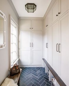 a hallway with white cabinets and blue flooring