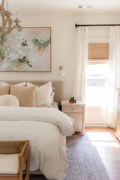 a white bed sitting in a bedroom next to a window