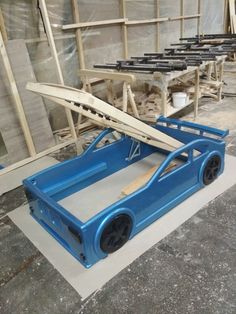 a blue car is being built in a building