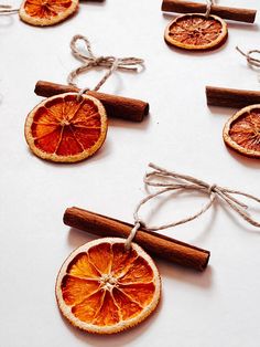 an orange cut in half and tied to twine with cinnamon stick on white surface