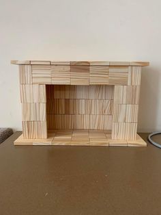 a small fireplace made out of wooden blocks on a table with a cord plugged into it