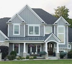 a large gray house with white trim and windows