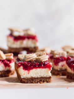 several desserts are arranged on a cutting board with crackers and cranberry sauce