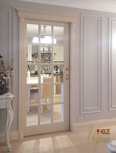 an open door leading to a kitchen and dining room with french doors on both sides