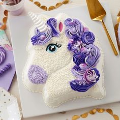 there is a cake that looks like a unicorn's head with purple flowers on it