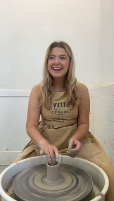 a woman sitting on top of a pottery wheel